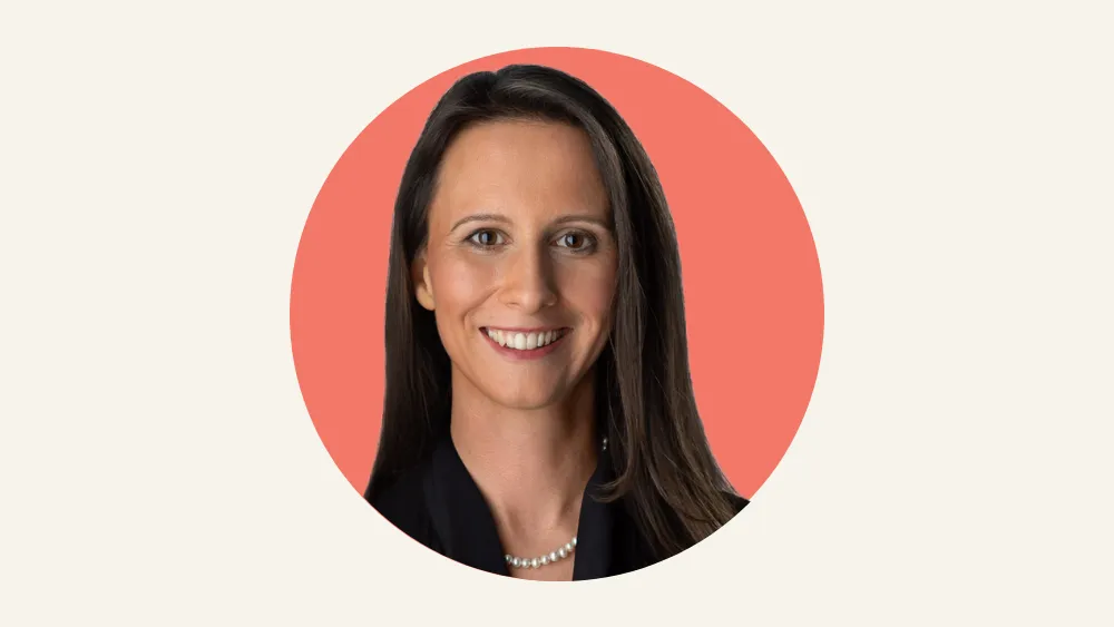 Portrait of a smiling woman with long brown hair against a coral circle background