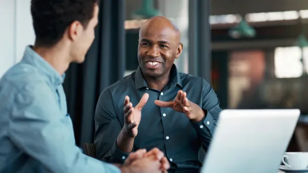 Two male office workers having a conversation in the office