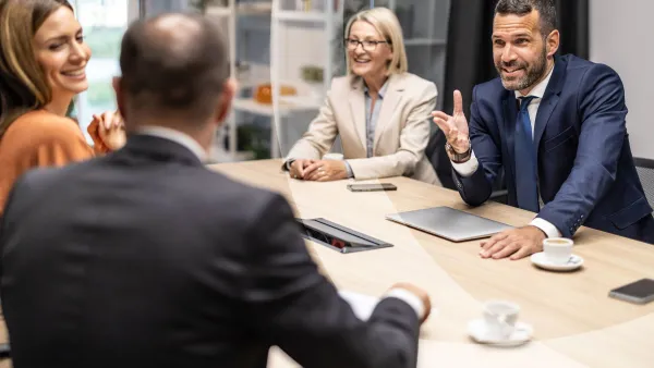 Group of business professionals having animated discussion around conference table