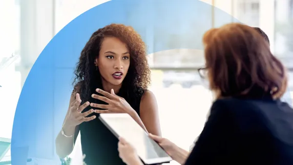 Colleagues in a professional discussion, with one holding a tablet